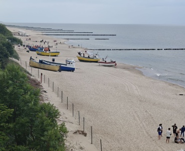 Zdjęcie 2024 rok: Spokojna plaża z łodziami rybackimi na piasku w Rewalu.